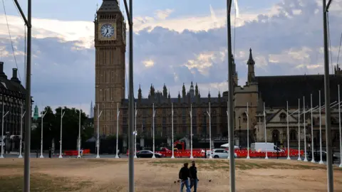 EPA There is a very barren and parched square with people walking across it.