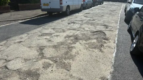 Kieran Molloy the middle of the road with damage and either side repaired