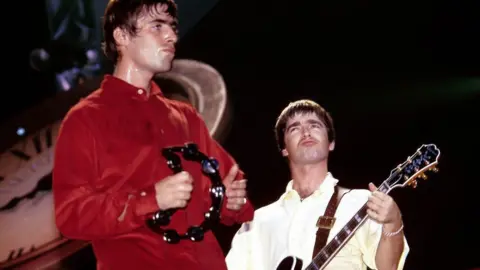 Getty Liam and Noel Gallagher rock on stage in the 1990s