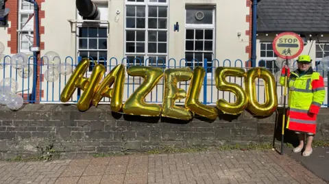 Pentyrch Primary School Hazel Davies with celebration balloons outside school