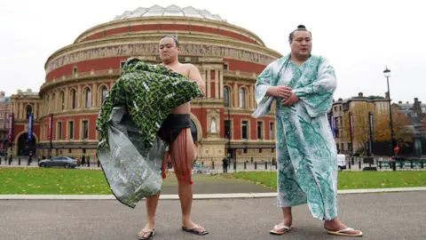 PA Media Two Sumo wrestlers in traditional costume stand in front of the Albert Hall. 