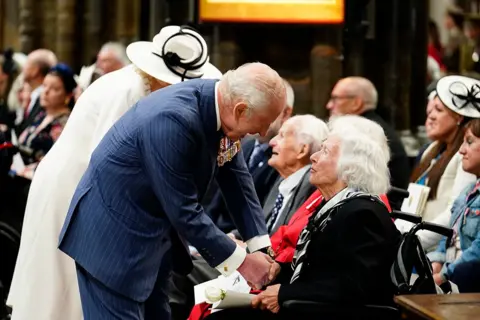 Jordan Pettitt/PA Media King Charles III and Queen Camilla speak with Second World War veterans and guest following a service of thanksgiving at Westminster Abbey in London on the 80th anniversary of VE Day.