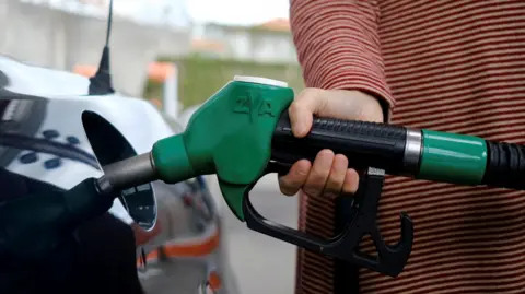 A person filling up their car with petrol