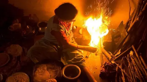 A woman cooks with firewood in her kitchen at Krishnagiri district in India's Tamil Nadu state in 2013.