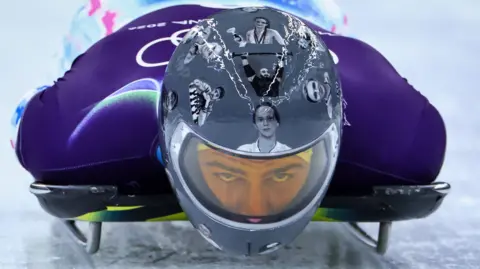 Ukrainian slider Vladyslav Heraskevych wears helmet with images of Ukrainian dead athletes during training run at Cortina sliding Centre, Italy during Winter Olympics