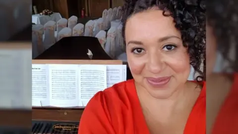 Thea Avison taking a selfie next to a piano.