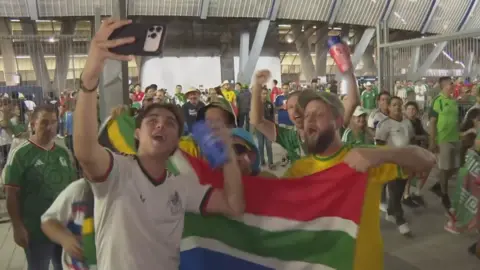 South African fans celebrating with a South African flag.