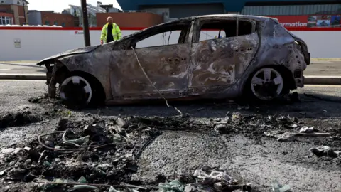 PA A shell of a burnt-out car.