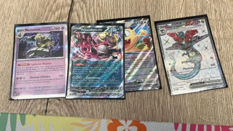 Darren Rozier/BBC Pokemon trading cards resting on a table. They all depict a different Pokemon with different statistics.