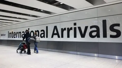Airline passengers in the arrivals hall at Heathrow Airport in London