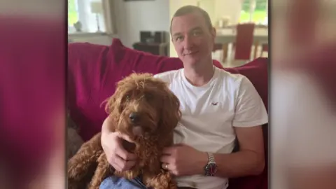Family handout John Walker, in a white T-shirt, cuddles his dog