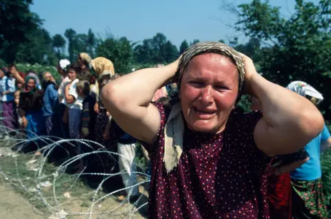 Sygma via Getty Images A woman in Srebrenica looking severely distressed
