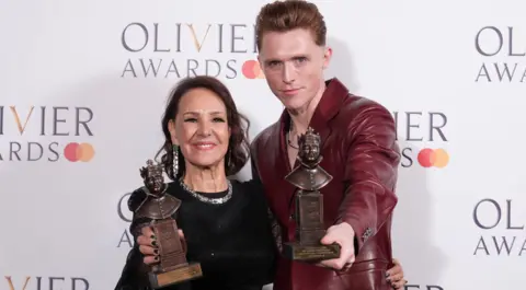 PA Media Arlene Phillips and James Cousins in the press room after being presented with the Best Theatre Choreographer award at the Olivier Awards at the Royal Albert Hall, London. Picture date: Sunday April 14, 2024