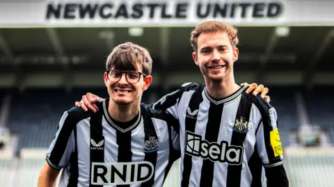 Lucy Ray/PA Media Assignments Newcastle United fans David Wilson (left) and Ryan Gregson with Sela's haptic shirts 