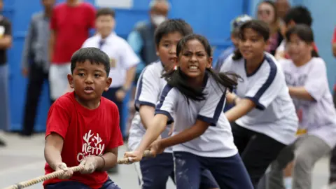 EPA Children take part in a tug of war competition. 