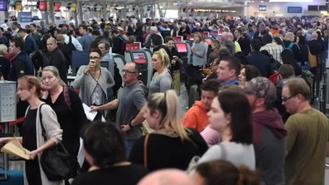 Reuters A large crowd of passengers queue up at Sydney Airport on Monday