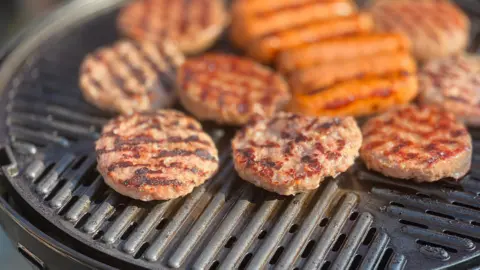 Beef burgers cooking on a home BBQ