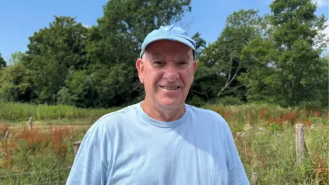 Ray Peck, chairman of the Friends of Hogsmill Stepping Stones group, looks straight at the camera.
