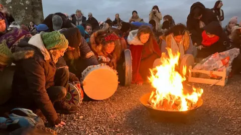 People celebrating winter solstice at Glastonbury Tor