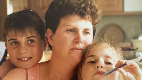 Sandy Duckett pictured with her son and daughter in their kitchen in the early 1980s