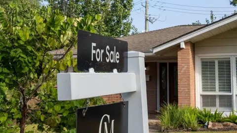 A for sale sign is seen in front of a house in a neighbourhood in Houston.