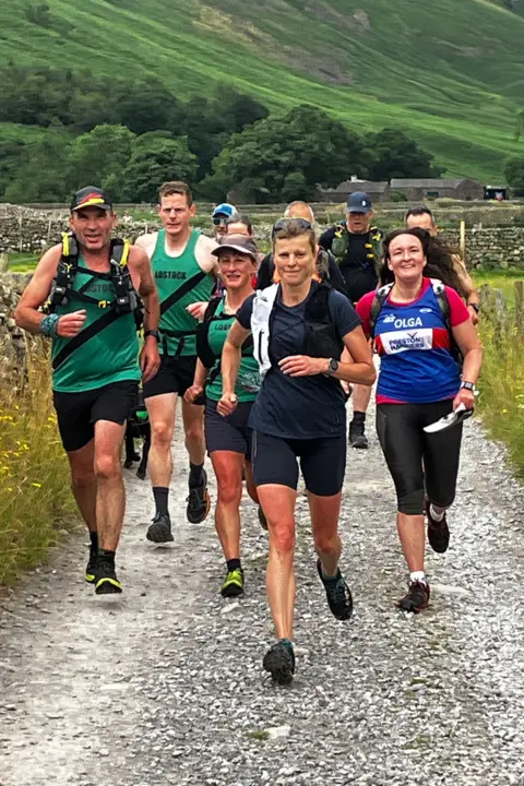 A group of runners wearing club colours head towards Wasdale Head