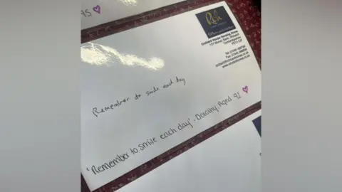 Orchard House Care Home A note is written on a white piece of card which has been laminated. The note says: "Remember to smile each day." It is written by Dorothy aged 92.