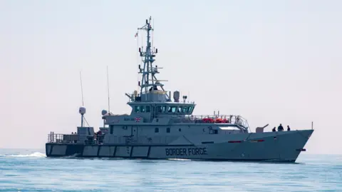 Getty Images A grey boat in a body of water. There is a Great Britain flag on the side along with "BORDER FORCE" in text.