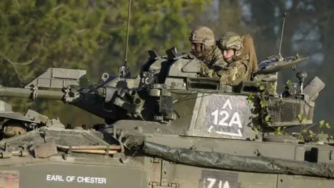 PA Media The Prince of Wales, Colonel-in-Chief, 1st Battalion Mercian Regiment (right), rides in an armoured vehicle while on a training exercise during a visit to the regiment, in the south west of the UK, for the first time following his appointment to the role by King Charles III.