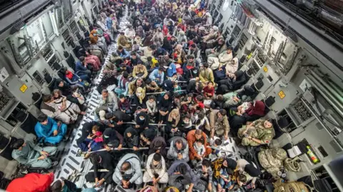 Ministry of Defence Evacuees are packed into the belly of an RAF transport plane