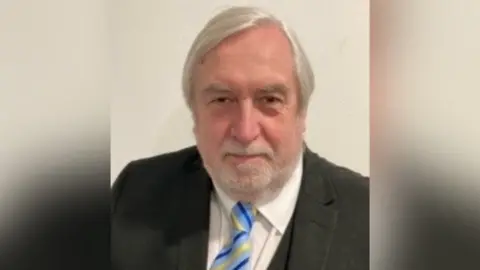 Harborough District Council A man with a beard in a suit and tie