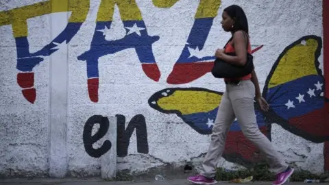 Reuters A woman walks past a mural calling for peace in Venezuela during the Constituent Assembly election in Caracas, Venezuela July 30, 2017.