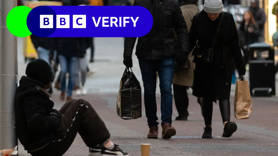 Shoppers walking past somebody begging in Leeds in December 2022