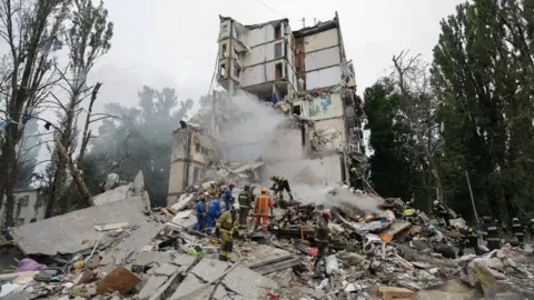 EPA/Shutterstock Rescuers work at the site of a Russian strike on a nine-storey residential building in Kyiv, Ukraine. Photo: 31 July 2025