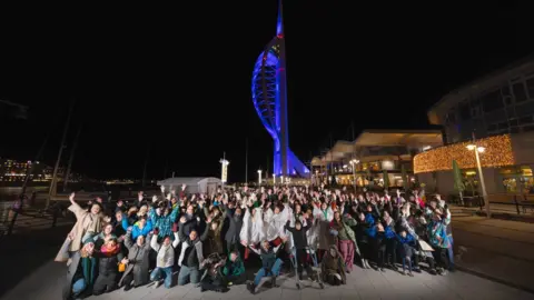 Image of a large group of people outside the Spinnaker Tower in Portsmouth