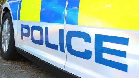 Suffolk Police Picture of a Police car- a white car with a blue police sign.
