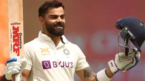 Virat Kohli raises his bat