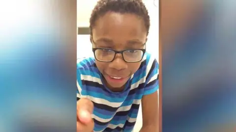 Family photo Christopher Kapessa in a blue striped T-shirt