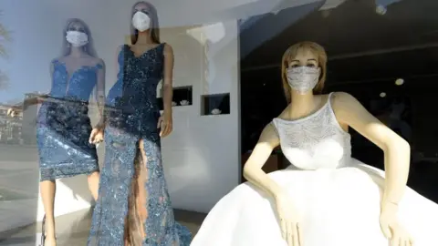 AFP Wedding shop window with bride wearing a face mask