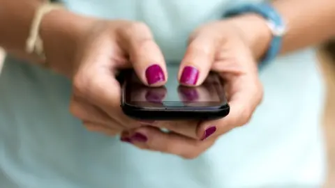 Getty Images Hands holding a smart phone