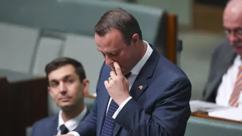 Reuters Tim Wilson reaches for a tear during his speech in parliament