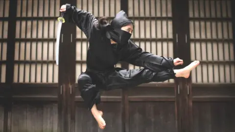 Getty Images Female ninja warrior leaping in the air