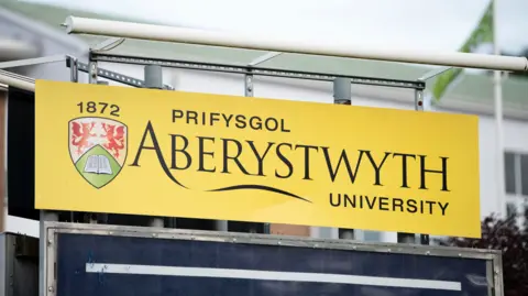 Getty Images A yellow sign which has Aberystwyth University written on it.