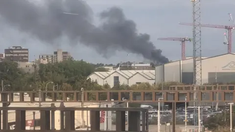 A dark plume of smoke coming from a commercial building in Luton. The smoke is billowing into the air.