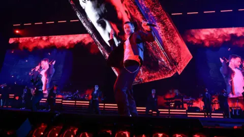 Getty Images Justin Timberlake performs onstage. He is dancing, wearing a white shirt and jacket.