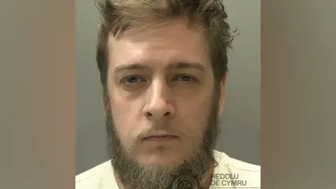 South Wales Police A Man's Dearers Image with A Beard and Whispee Mustache 