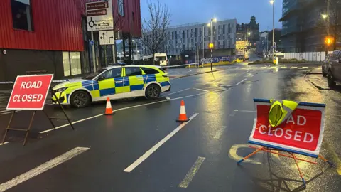 A cordon and police cars 