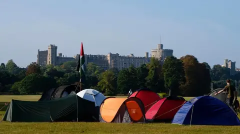 PA A group of about eight small tents in a park with Windsor Castle in the distance