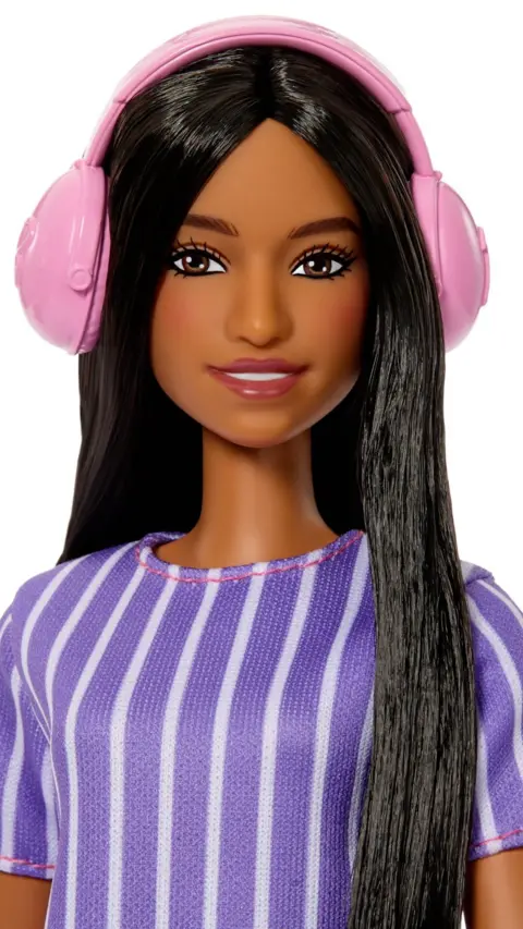 Barbie doll with long dark hair, wears pink headphones.