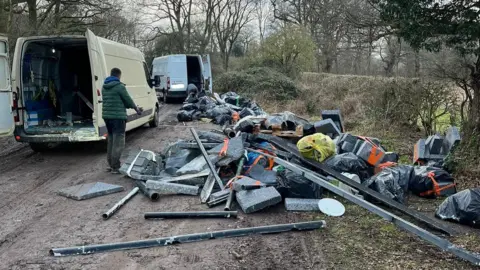 Warwickshire Police vans and rubbish in a country lane